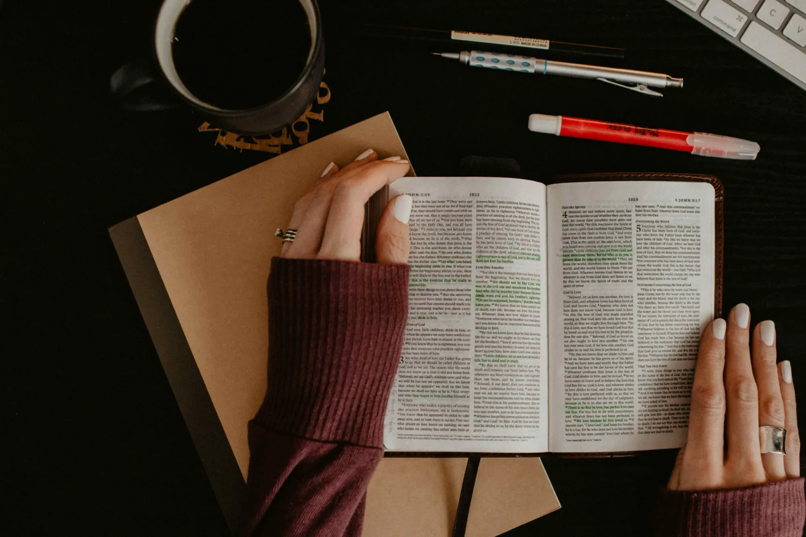 Couples hands resting on an open Bible.
